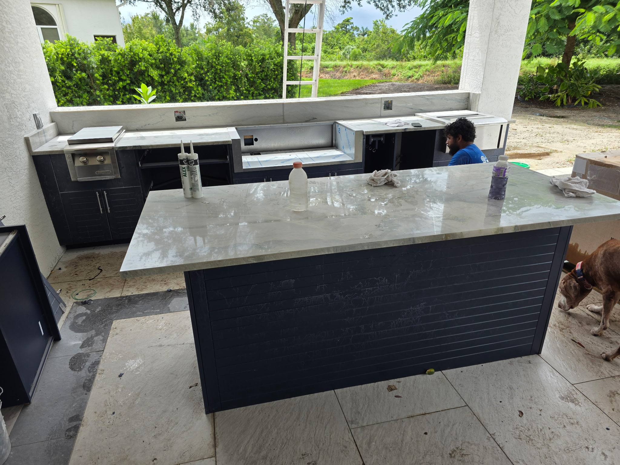 Outdoor kitchen South Florida β navy cabinets quartzite countertops wood ceiling